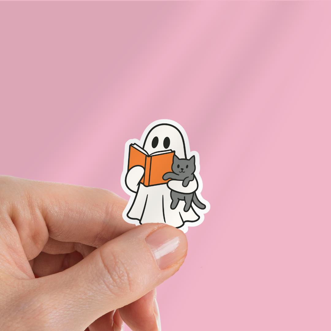 Bookish Ghost Holding Cat Kindle Sticker: Halloween Sticker sticker by Magic & Meaning